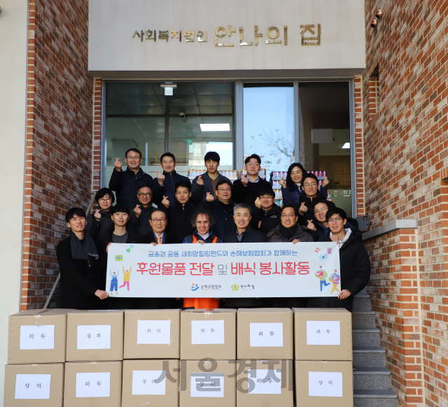 김용덕(앞줄 왼쪽 세번째) 손해보험협회장과 임직원들이 20일 경기도 성남의 노숙인 보호시설인 안나의집에서 후원물품 전달식 및 배식 봉사활동을 진행하고 손가락 하트를 만들며 활짝 웃고 있다. /사진제공=손보협회