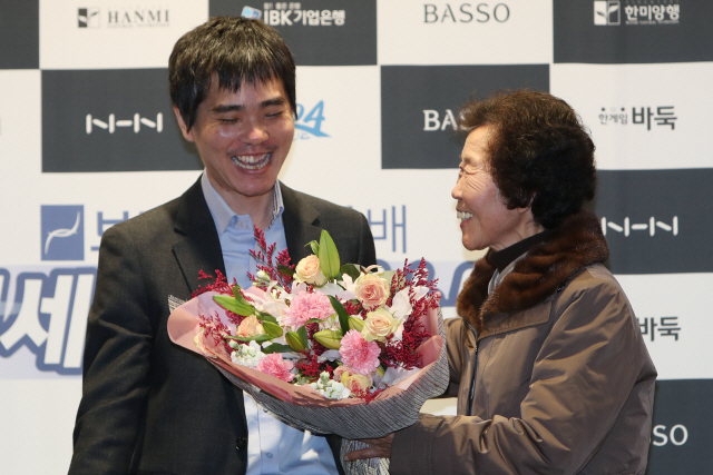 이세돌(왼쪽)이 지난 21일 국내 AI 한돌과의 은퇴 대국을 마친 뒤 어머니 박양례씨로부터 꽃다발을 받으며 환하게 웃고 있다. /연합뉴스