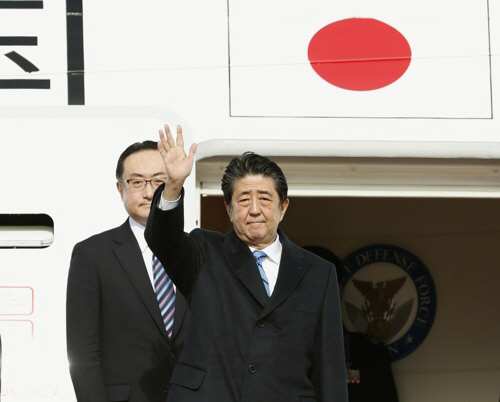 아베 신조 일본 총리가 23일 도쿄 하네다공항에서 중국으로 가는 전용기에 올라 취재진을 향해 손을 들어보이고 있다./도쿄=교도연합뉴스