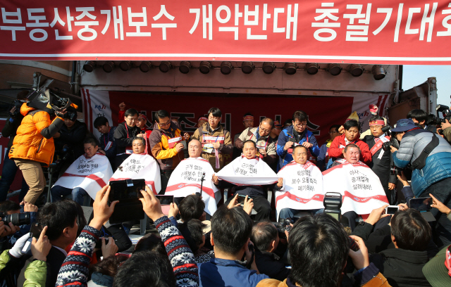 정부가 2014년 11월 부동산 중개수수료 개편안을 마련하자 공인중개사들이 서울역 광장에서 중개보수 인하에 반대하며 삭발 시위를 벌이고 있다. /연합뉴스