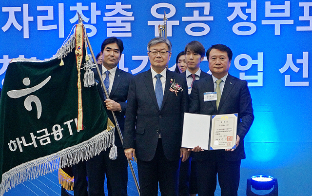 유시완(앞줄 오른쪽 첫번째) 하나금융티아이 대표가 지난 23일 세종시 세종컨벤션센터에서 열린 고용노동부 주관 ‘2019년 일자리 창출 유공 정부포상’ 시상식에서 이재갑(〃 두번째) 고용노동부 장관으로부터 대통령 표창을 수상하고 있다./사진제공=하나금융TI