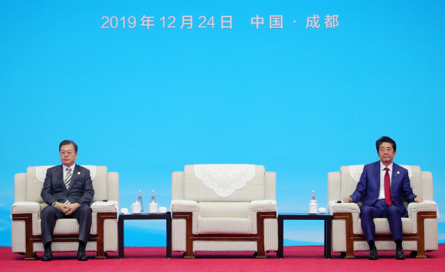 문재인 대통령과 아베 일본 총리가 24일(현지시간) 쓰촨성 청두 세기성 박람회장에서 열린 한중일 비즈니스 서밋에 참석해 리커창 중국 총리의 발언을 듣고 있다./청두=연합뉴스