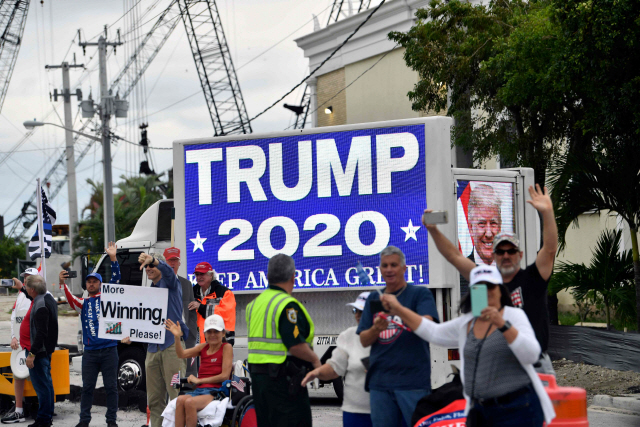 도널드 트럼프 미국 대통령 지지자들이 24일(현지시간) 플로리다의 웨스트 팜비치 마러라고 리조트 인근에서 트럼프 대통령의 차량 행렬에 환호하고 있다./AFP연합뉴스