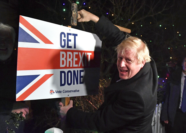 보리스 존슨 영국 총리가 총선을 하루 앞둔 12월11일 밤(현지시간) 런던 동부 벤플리트에 위치한 한 지지자의 정원에서 ‘브렉시트를 마무리 짓자’라고 적힌 팻말에 망치질을 하고 있다./런던=AP연합뉴스