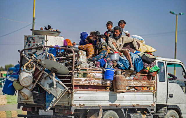 시리아 북부에서 터키군의 공격으로 한 쿠르드 가족이 피란을 떠나고 있다./AFP연합뉴스