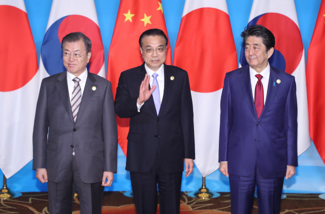 문재인(왼쪽) 대통령과 아베 신조(오른쪽) 일본 총리, 리커창 중국 총리가 24일 쓰촨성 청두 세기성 국제회의센터에서 3국 정상회의에 앞서 기념촬영을 하고 있다. /청두=연합뉴스