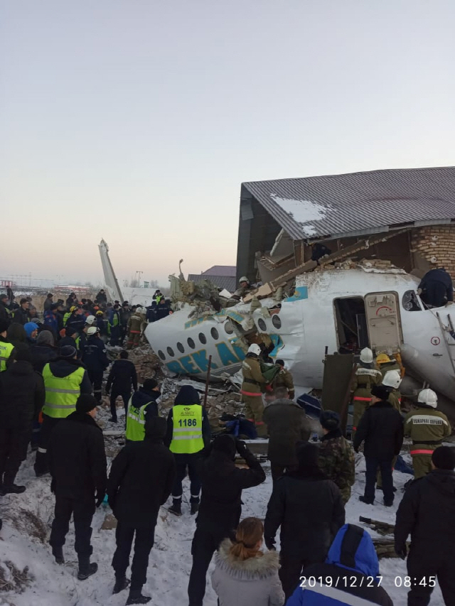 카자흐스탄 경찰과 응급요원들이 27일(현지시간) 알마티국제공항 인근 항공기 추락사고 현장을 살피고 있다. 이 사고로 최소 12명이 숨지고 66명이 부상했다.   /알마티=로이터연합뉴스