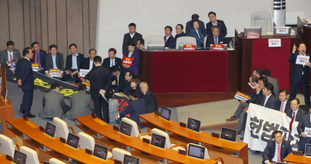 ‘공직선거법 개정안’ 본회의 투표를 앞두고 27일 국회 본회의장에서 자유한국당 의원들이 손팻말과 현수막을 펼치며 국회 의장석 주변을 둘러싸고 있다./연합뉴스