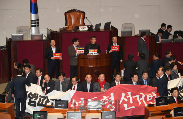 ‘공직선거법 개정안’ 본회의 투표를 앞두고 27일 국회 본회의장에서 자유한국당 의원들이 손팻말과 현수막을 펼치며 국회 의장석 주변을 둘러싸고 있다./이호재기자