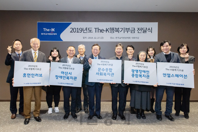 차성수(왼쪽 여섯째) 한국 교직원공제회 이사장이 27일 진행된 ‘The-K 행복기부금 전달식에서’ 관계자들과 함께 손가락 하트를 만들며 활짝 웃고 있다./사진제공=교직원공제회