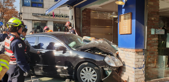 28일 오전 서울 동작구 사당동 도로 인근에서 승용차가 갑자기 도로 옆 커피숍으로 돌진해 커피숍이 크게 부서졌다. 경찰과 소방 관계자들이 사고 조사를 하고 있다./독자 제공