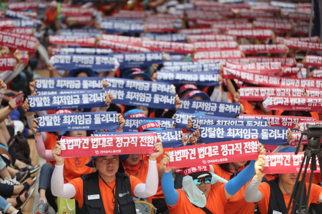 지난 8월 20일 서울 중구 서울고용노동청 앞에서 금속노조 기아차 비정규직지회 조합원들이 구호가 적힌 손팻말을 들고 있다. /연합뉴스