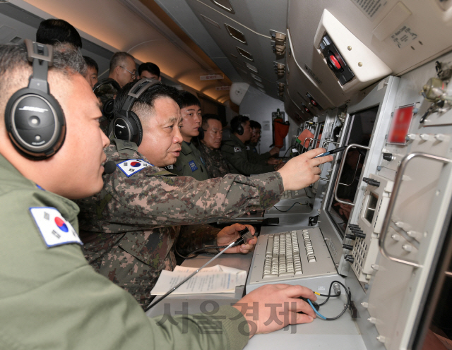 박한기 합창의장(사진 왼쪽에서 두번째)이 공군의 항공통제기인 E-737 피스아이에서 공군 관제요원들의 보고를 들으며 육해공군 각 부대의 대비 태세를 점검하고 있다./사진= 합참 제공