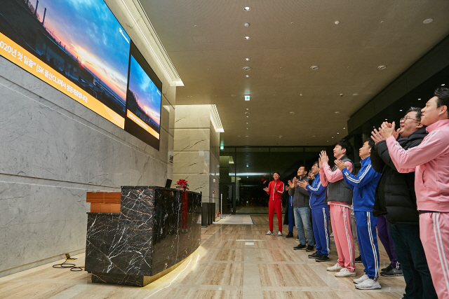 SK이노베이션 구성원들이 1일 서울 SK서린사옥 1층 로비에서 대형 미디어월로 SK울산CLX의 새해 첫 일출 장면을 지켜보고 있다. /사진제공=SK이노베이션