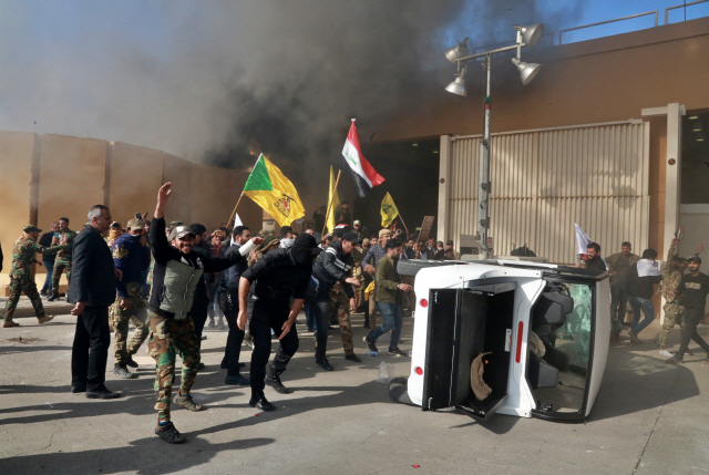 31일(현지시간) 이라크 내 친이란 시아파 민병대 카타이브-헤즈볼라를 폭격한 미국에 항의하는 시위대가 바그다드 주재 미 대사관에 진입, 기물을 부수고 불을 지르고 있다./바그다드=AP연합뉴스