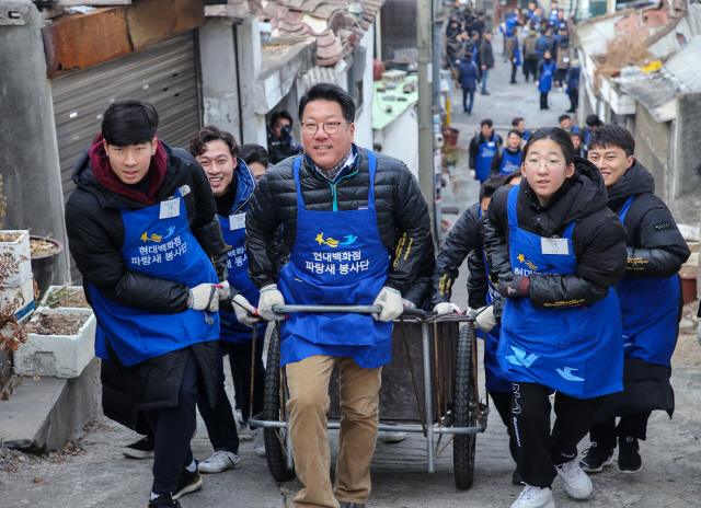 정지선(가운데) 현대백화점그룹 회장이 2일 서울 노원구 중계본동 백사마을에서 임직원 등과 함께 연탄을 실은 손수레를 끌고 골목을 오르고 있다. 현대백화점그룹은 이날 ‘밥상공동체복지재단’이 운영하는 연탄은행에 총 25만장의 연탄을 기부했다. /사진제공=현대백화점그룹