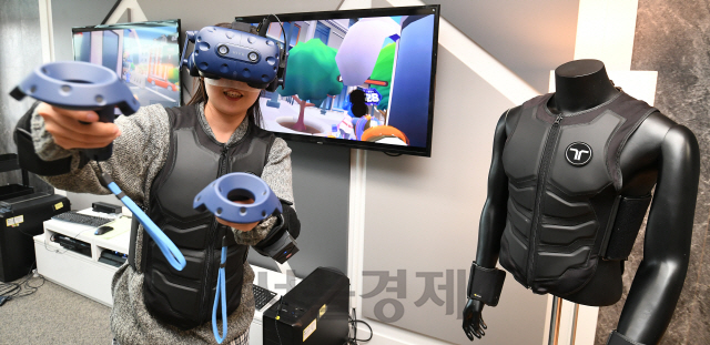 권경원 서울경제 기자가 대전시 유성구 소재 비햅틱스에서 웨어러블 햅틱 슈트인 ‘택슈트’를 입고 VR 게임을 체험하고 있다./대전=오승현기자