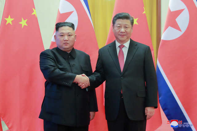 4차 방중한 김정은(왼쪽) 북한 국무위원장이 지난해 1월8일 인민대회당에서 시진핑 중국 국가주석과 악수하고 있다./연합뉴스