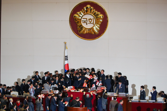 ‘공직선거법 개정안’ 투표가 예정된 지난해 12월 27일 국회 본회의장에서 문희상 국회의장이 자유한국당 의원들의 육탄저지를 뚫고 의장석에 착석한 뒤에도 거센 항의를 받고 있다. /연합뉴스