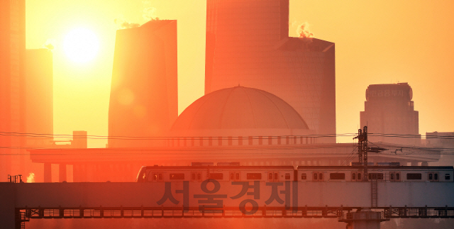 지하철 2호선에 몸을 싣고 각자의 일터로 향하는 시민들이 서울 여의도 국회의사당 뒤로 떠오른 2020년 경자년(庚子年) 새로운 태양과 마주하고 있다./오승현기자