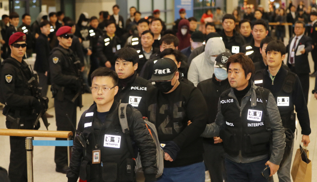 경찰이 지난 2017년 말 필리핀에서 국외도피사범 47명을 검거해 인천공항을 통해 국내로 압송하고 있다./연합뉴스