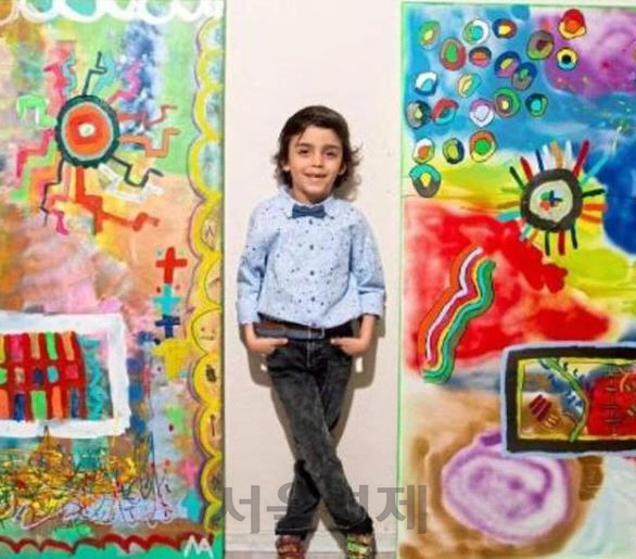 8세 미술 신동 미카일 아카르가 자신이 그린 그림 앞에서 포즈를 취하고 있다. /아카르 인스타그램 캡처