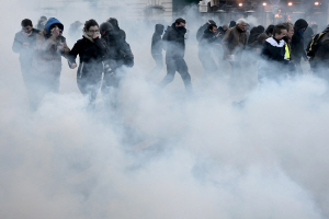 프랑스 시위대가 11일(현지시간) 파리에서 경찰이 쏜 최루가스를 피하고 있다. /파리=AFP연합뉴스