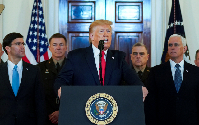 도널드 트럼프(가운데) 미국 대통령이 8일(현지시간) 백악관에서 마이크 펜스(오른쪽) 부통령 등 참모진이 도열한 가운데 이란의 이라크 내 미군기지 탄도미사일 공격 관련 대국민연설을 하고 있다.  /워싱턴DC=로이터연합뉴스