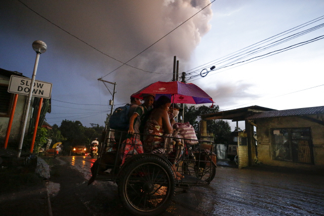 필리핀 수도 마닐라에서 남쪽으로 65㎞가량 떨어진 섬에서 12일(현지시간) 탈 화산이 폭발하자 타가이타이 주민들이 대피하고 있다. /타가이타이=AP연합뉴스