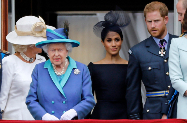지난해 7월 영국 엘리자베스 2세(왼쪽) 여왕, 해리(오른쪽) 왕자, 부인 메건 마클(가운데) 왕자비가 한 행사에서 나란히 서있다./AFP연합뉴스