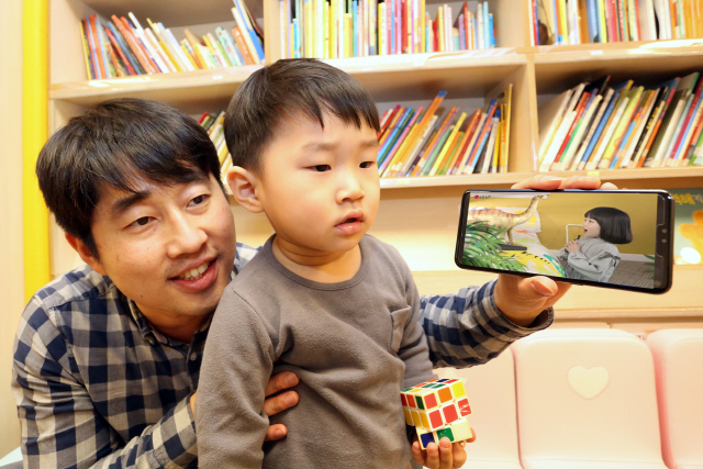 LG유플러스 모델이 동화와 자연관찰, 과학 등의 콘텐츠를 3D AR로 생동감있게 즐길 수 있는 모바일 교육 애플리케이션 ‘U+아이들생생도서관’을 소개하고 있다./사진제공=LG유플러스