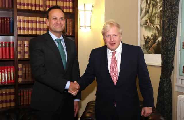보리스 존슨(오른쪽) 영국 총리와 리오 버라드커 아일랜드 총리가 13일(현지시간) 북아일랜드 벨파스트에서 악수를 나누고 있다. /벨파스트=AFP연합뉴스