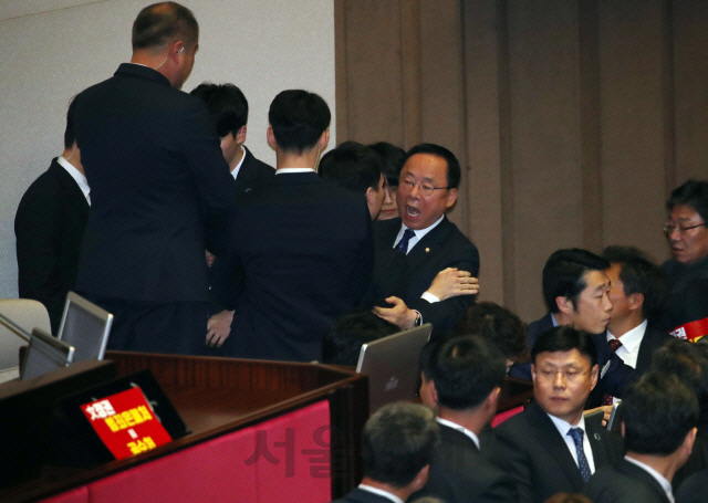 자유한국당 소속 이주영(가운데) 국회부의장이 30일 고위공직자범죄수사처법 본회의 표결을 앞두고 의장석으로 올라가려다 국회 경위들에게 제지당하자 고함을 치며 항의하고 있다. /연합뉴스