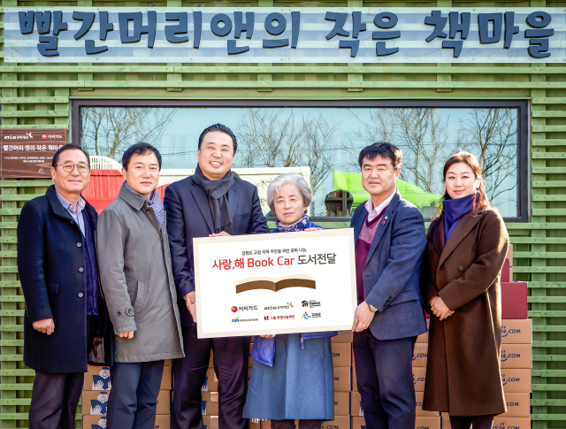 김영선(왼쪽 세번째)BC카드 홍보팀장이 지난 14일 지난해 산불로 인해 전소됐다가 다시 개관하는 강원도 고성군 작은도서관 ‘빨간머리 앤의 작은 책마을’에 예스24와 함께 ‘사랑,해 Book Car’를 파견하고 서적과 도서관 운영 물품을 박영숙(왼쪽 네번째)관장, 김창래(오른쪽 두번째)고성군 관광문화과장 등에게 전달하고 있다. /사진제공=BC카드