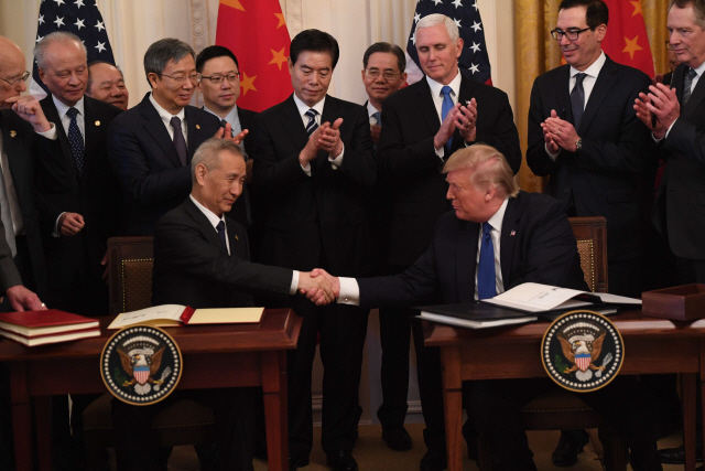 도널드 트럼프(오른쪽) 미국 대통령과 류허 중국 부총리가 15일(현지시간) 워싱턴DC 백악관에서 미중 1단계 무역 합의안에 서명한 뒤 악수하고 있다./워싱턴 AFP=연합뉴스
