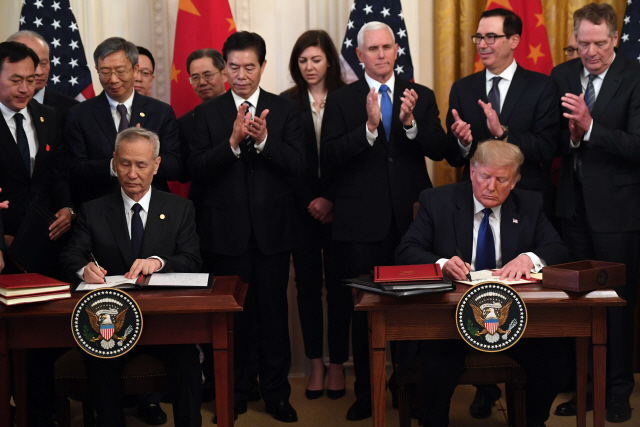 도널드 트럼프(오른쪽) 미국 대통령과 류허 중국 부총리가 15일(현지시간) 미 백악관에서 미중 1단계 무역 합의안에 서명하고 있다. /워싱턴DC=AFP연합뉴스