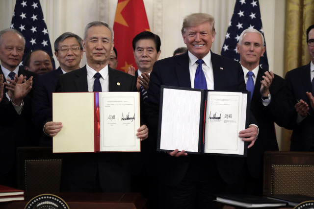 도널드 트럼프(오른쪽) 미국 대통령과 류허 중국 부총리가 15일(현지시간) 백악관에서 미중 1단계 무역 합의안에 서명한 뒤 이를 들어보이고 있다. /워싱턴DC=AP연합뉴스