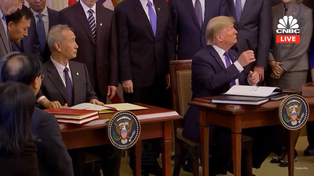 도널드 트럼프(오른쪽) 미국 대통령이 류허 중국 부총리와 15일(현지시간) 미 백악관에서 1단계 무역합의에 서명한 뒤 관계자들과 이야기를 나누고 있다. /CNBC 화면캡쳐