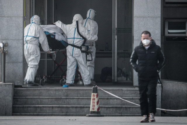 신종 코로나바이러스로 알려진 ‘우한 폐렴’이 발생한 중국 후베이성 우한에서 18일 의료진이 폐렴환자들을 집중 치료하는 한 병원으로 환자를 옮기고 있다. /연합뉴스