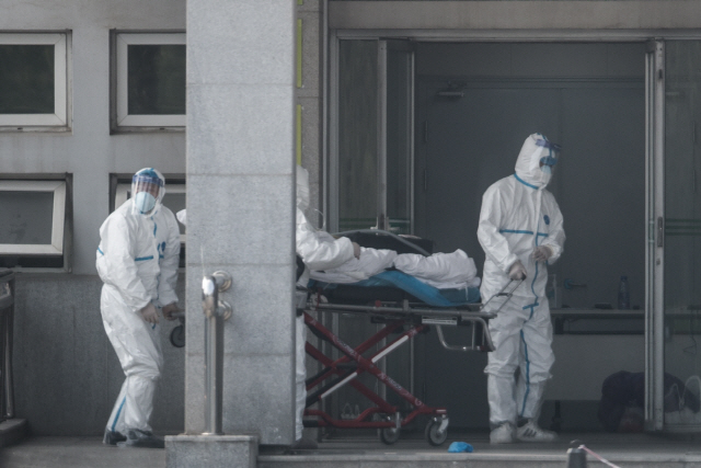 지난 18일 중국 우한에서 의료진이 ‘우한 폐렴’으로 불리는 중국 신종 코로나 바이러스 감염증 환자를 병원으로 이송하고 있다./EPA연합뉴스