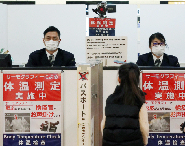 ‘우한 폐렴’ 전세계 확산 가능성에 전세계 공항에 비상이 걸렸다. 지난 16일 일본 나리타공항에서 입국 심사 직원들이 마스크를 쓴 채 업무를 하고 있다./지지통신·연합뉴스