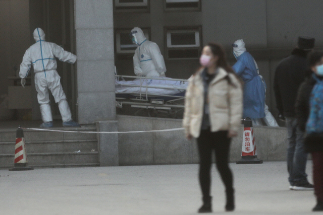 20일 중국 의료진이 후베이성 성도인 우한에 있는 진인탄 병원으로 신종 코로나바이러스에 감염된 환자를 이송하고 있다.    /우한=로이터연합뉴스