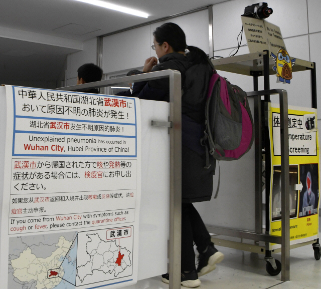 지난 16일 일본 도쿄 근교 나리타공항에서 중국 우한에서 온 입국자들이 검역대를 지나고 있다./나리타=교도연합뉴스