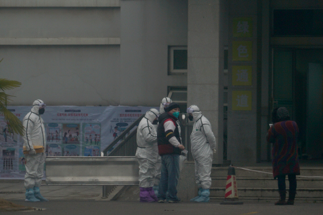 21일(현지시간) 중국 허베이성 우한시의 한 병원에서 방역복을 입은 직원이 서있다./우한=AP연합뉴스