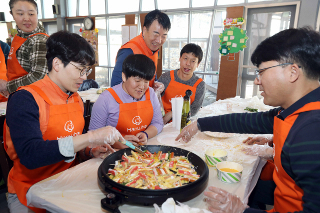 한화그룹 신임 임원들이 21일 인천시 강화도우리마을에서 열린 ‘2020 신임 임원 봉사활동’에 참가해 발달장애인들과 설 명절 음식을 만들고 있다. /사진제공=한화