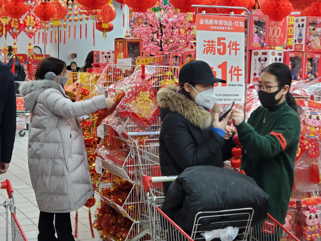 23일 중국 베이징의 대형마트에서 손님들이 춘제 장식품을 고르고 있다. /최수문기자