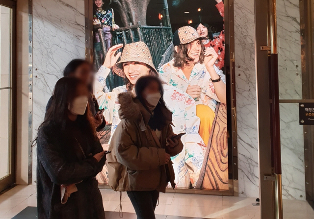 마스크를 착용한 중국인 관광객들이 23일 서울 중구 명동의 한 백화점으로 들어가고 있다. /이희조기자