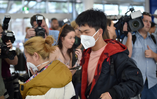 중국 우한에서 출발한 여객기 승객들이 23일 마스크를 착용한 채 호주 시드니 공항에 도착하고 있다. 이들이 타고 온 항공편은 우한 폐렴 봉쇄 조치가 내려지기 전 마지막으로 운항된 항공편의 하나로, 호주 당국은 의심 증상자는 없었다고 밝혔다. /연합뉴스