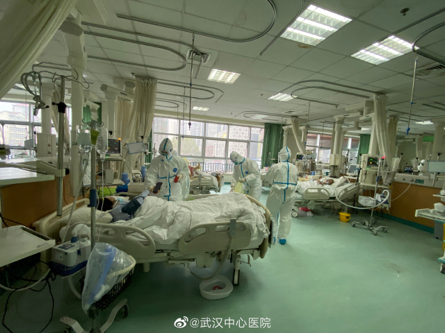 신종 코로나바이러스인 ‘우한 폐렴’ 발원지인 중국 후베이성 우한시의 중앙병원의 병실에서 의료진이 환자들을 진료하고 있다. /우한=로이터연합뉴스