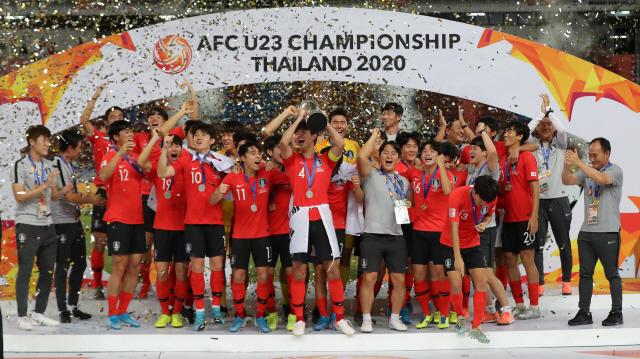 한국 축구 대표팀이 AFC U-23 챔피언십에서 우승한 뒤 27일 시상식에서 트로피를 들고 환호하고 있다. 오른쪽은 김학범 감독. /연합뉴스